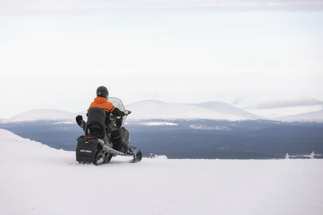 FI: Moottorikelkkailija pysähtyy tunturin rinteelle ihailemaan avaraa lumimaisemaa ja kaukaisia tuntureita Muoniossa, Lapissa – Snowmobile Fell Adventure osana Harriniva Hotels & Safarisin Best of Lapland Arctic -täyshoitolomapakettia.
EN: A snowmobiler pauses on a fell slope to admire the wide snowy panorama and distant fells in Muonio, Lapland—Snowmobile Fell Adventure as part of Harriniva Hotels & Safaris’ Best of Lapland Arctic all-inclusive holiday package.