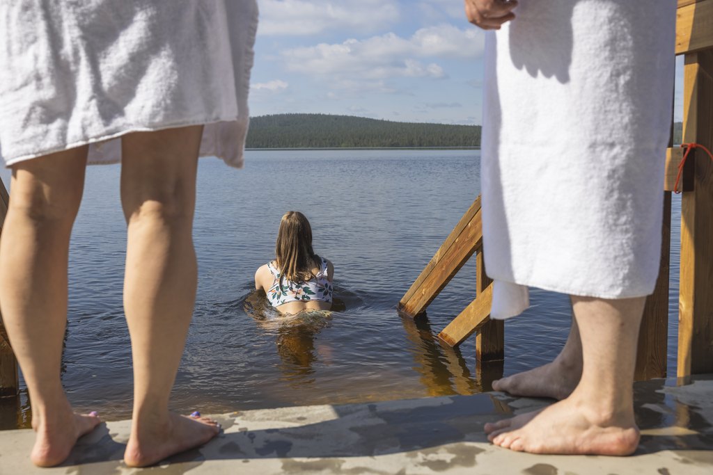 Guests enjoying a refreshing swim in Lake Jerisjärvi at Arctic Sauna World, Lapland, Finland